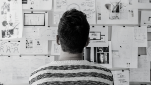 Back of man's head as he look at designs and papers