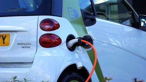 Driving the Electric Revolution: an electric car shown from behind, plugged in charging